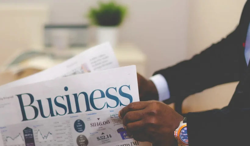 Businessman opening a paper and reading articles about capitalism