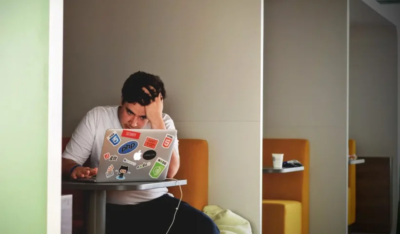 A man with a MacBook contemplating the startup ideas