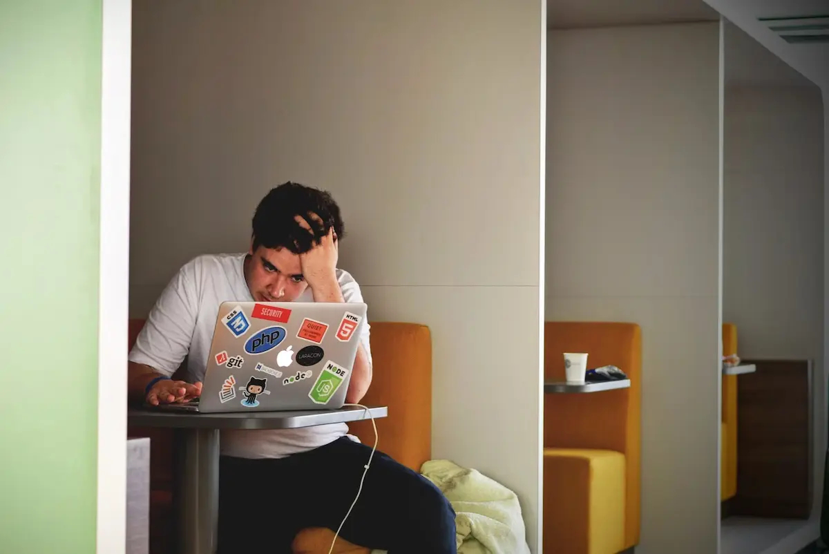 A man with a MacBook contemplating the startup ideas