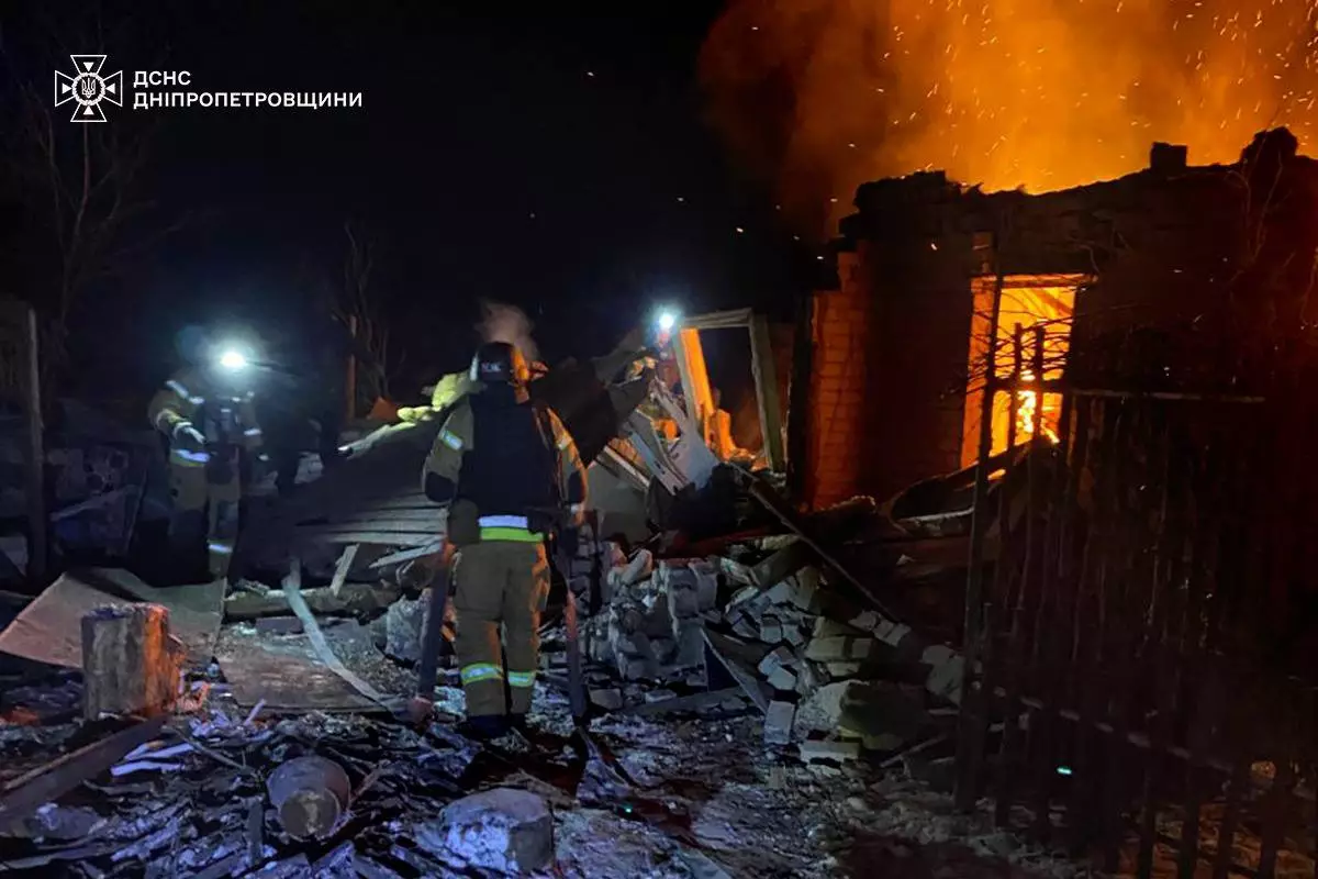 Рятувальники гасять пожежу вночі після обстрілу, зруйновані будівлі, вогонь і дим на фоні