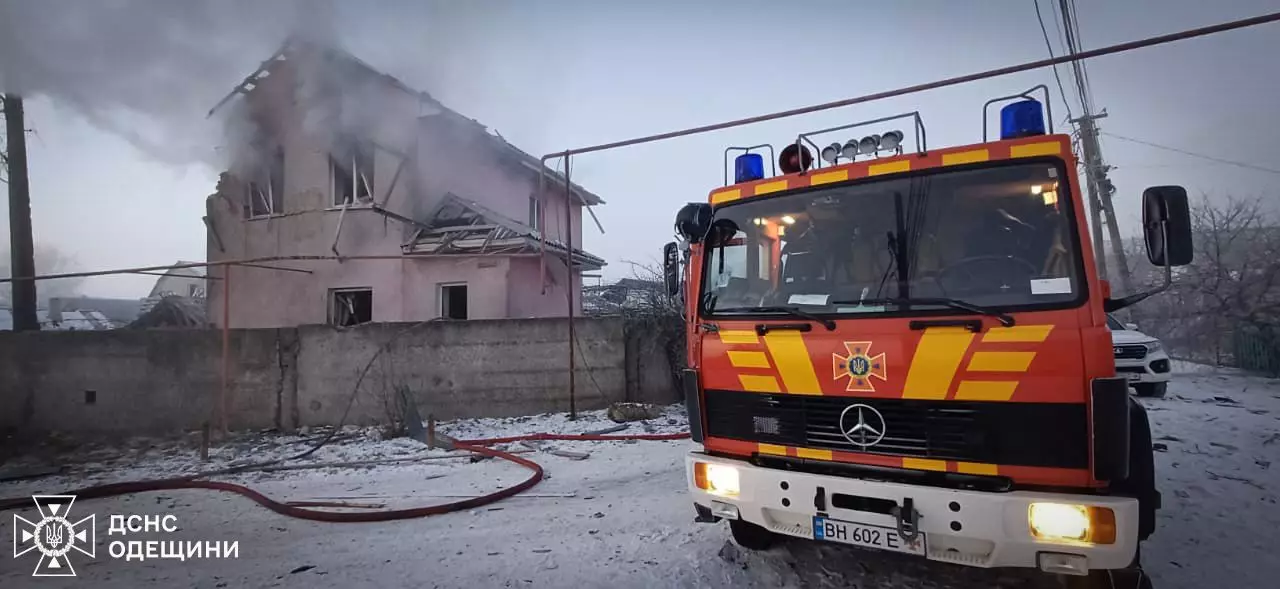 Пожежна машина біля зруйнованого будинку після обстрілу, дим піднімається з-під даху