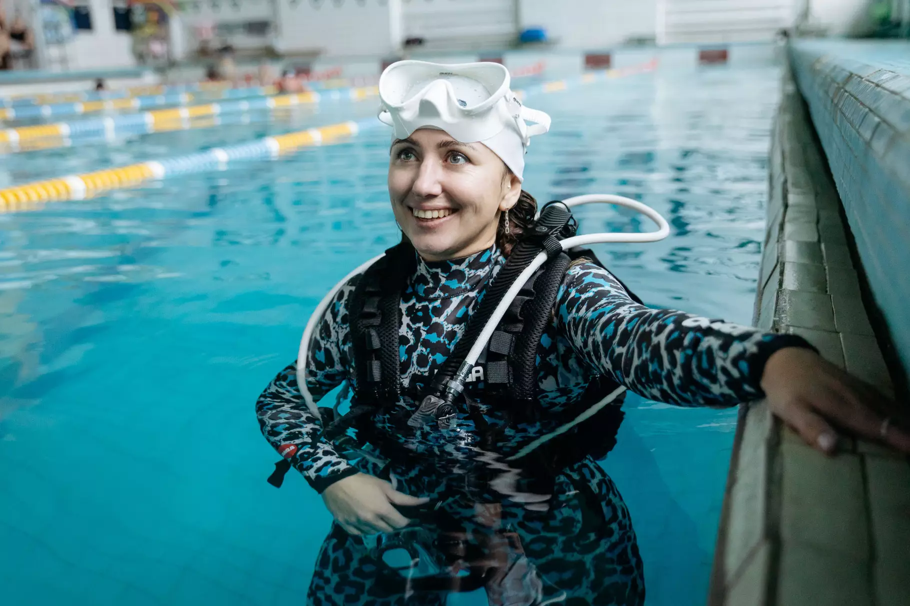 Жінка в дайвінг-спорядженні посміхається у басейні під час реабілітаційного заняття для ветеранів