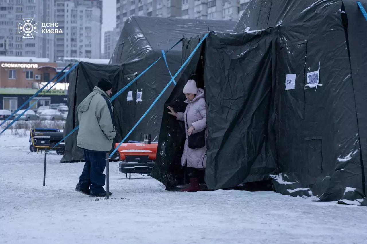 Люди біля тимчасових наметів у сніжному Києві, організованих для допомоги постраждалим від атаки