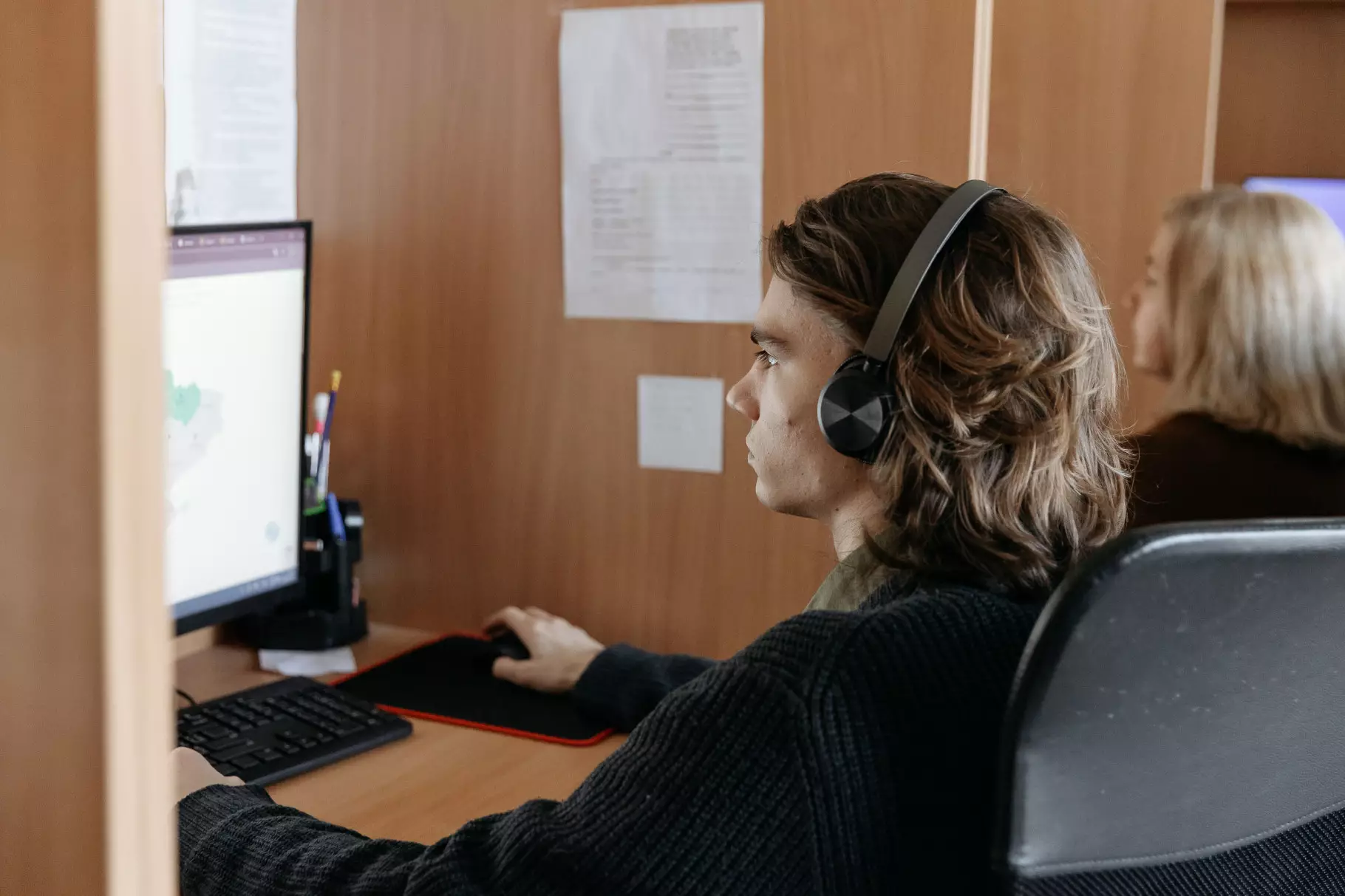 Оператор контактного центру МВС працює за комп'ютером, використовуючи навушники для спілкування з абонентами