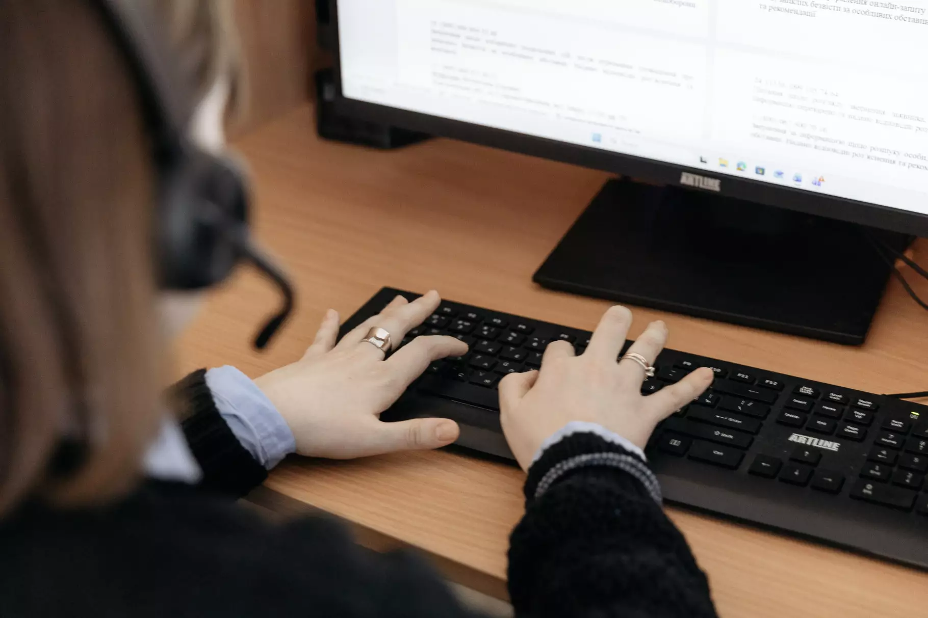 Оператор контактного центру МВС працює за комп'ютером, приймаючи дзвінки громадян через гарнітуру