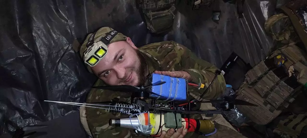 Прикордонник у камуфляжі тримає ударний БПЛА, готовий до бойового завдання в польових умовах