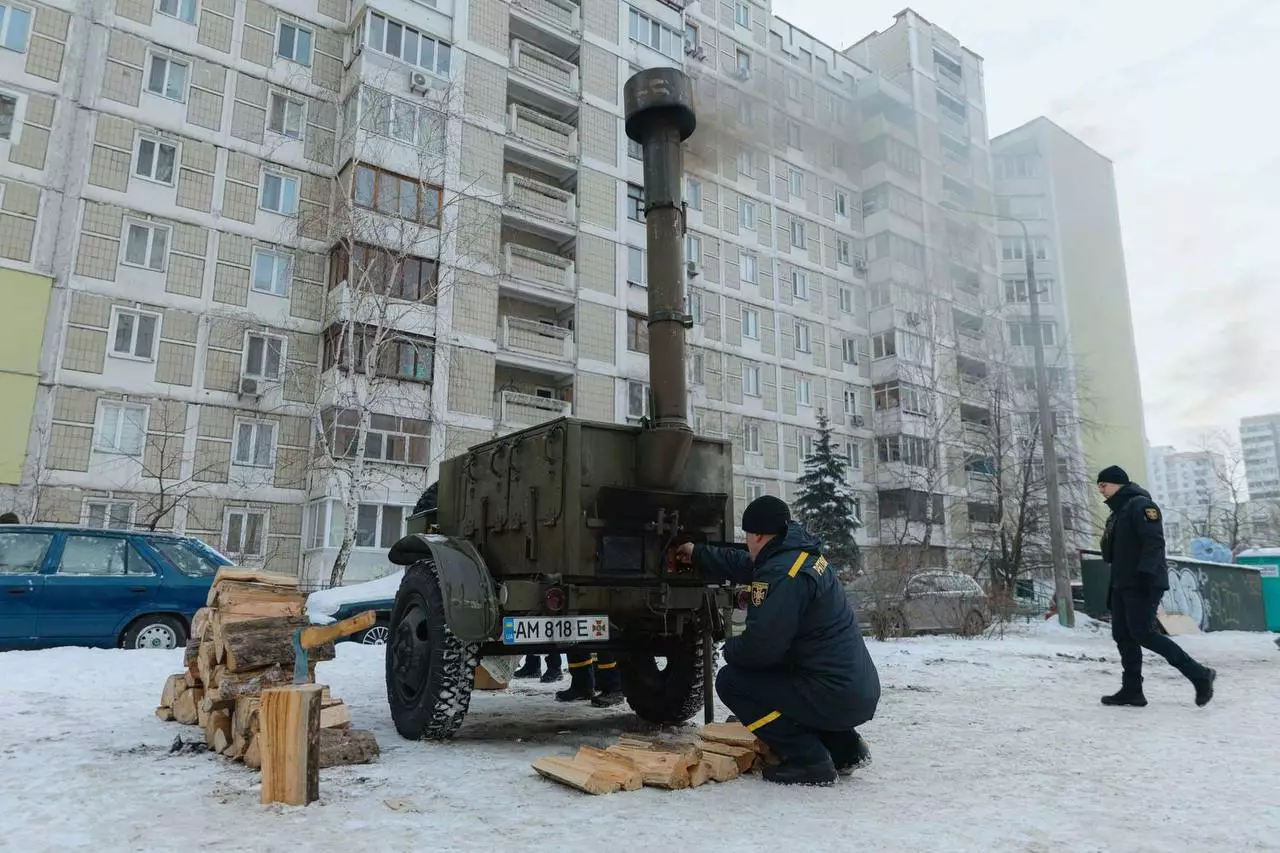 Рятувальники ДСНС розгортають мобільну піч для обігріву біля багатоповерхівки в засніженому Києві