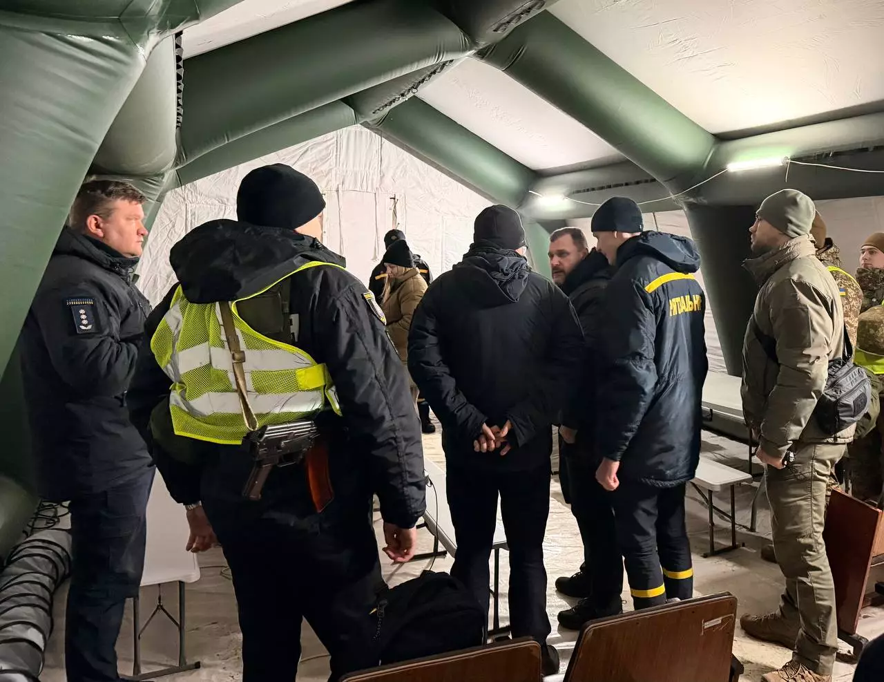 Рятувальники та військові обговорюють розгортання пункту обігріву в наметі під час зимових умов у Києві