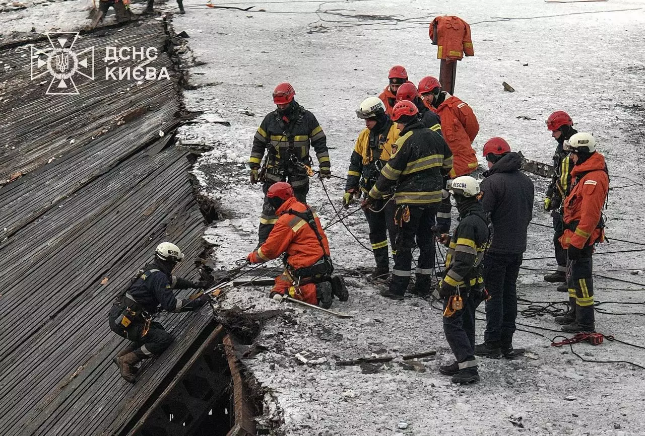 Рятувальники ДСНС у зимовому одязі працюють на місці обвалу даху, використовуючи спеціальне обладнання
