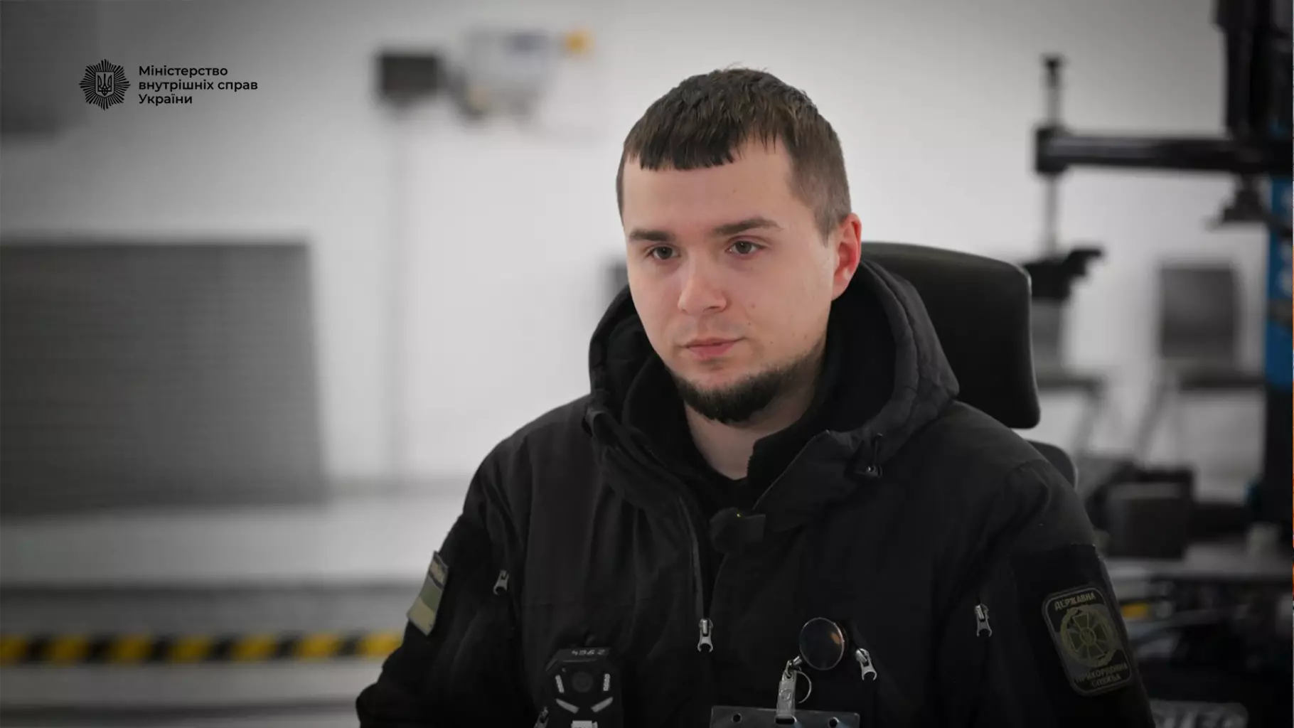 Прикордонник у формі Державної прикордонної служби України на фоні службового приміщення