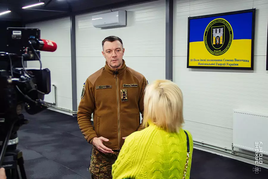 Військовий у формі Нацгвардії України дає інтерв'ю журналістці в приміщенні реабілітаційного центру
