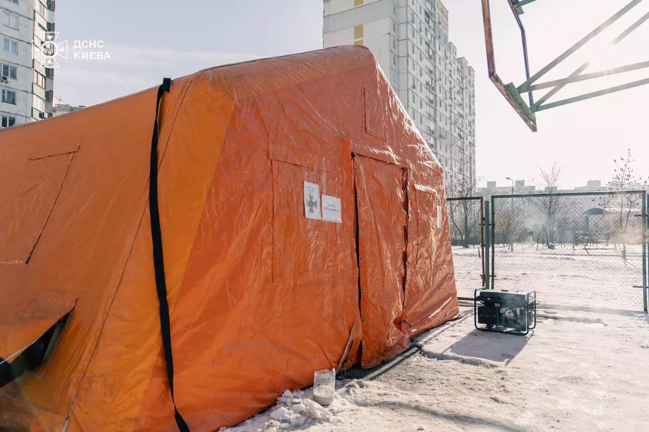 Помаранчевий намет ДСНС України для обігріву громадян на тлі багатоповерхівок у Києві