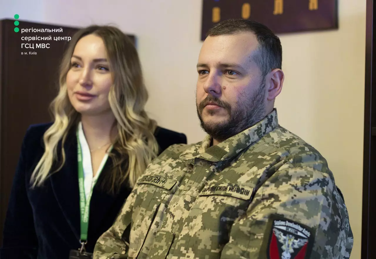 Чоловік у військовій формі та жінка в офісі сервісного центру МВС у Києві