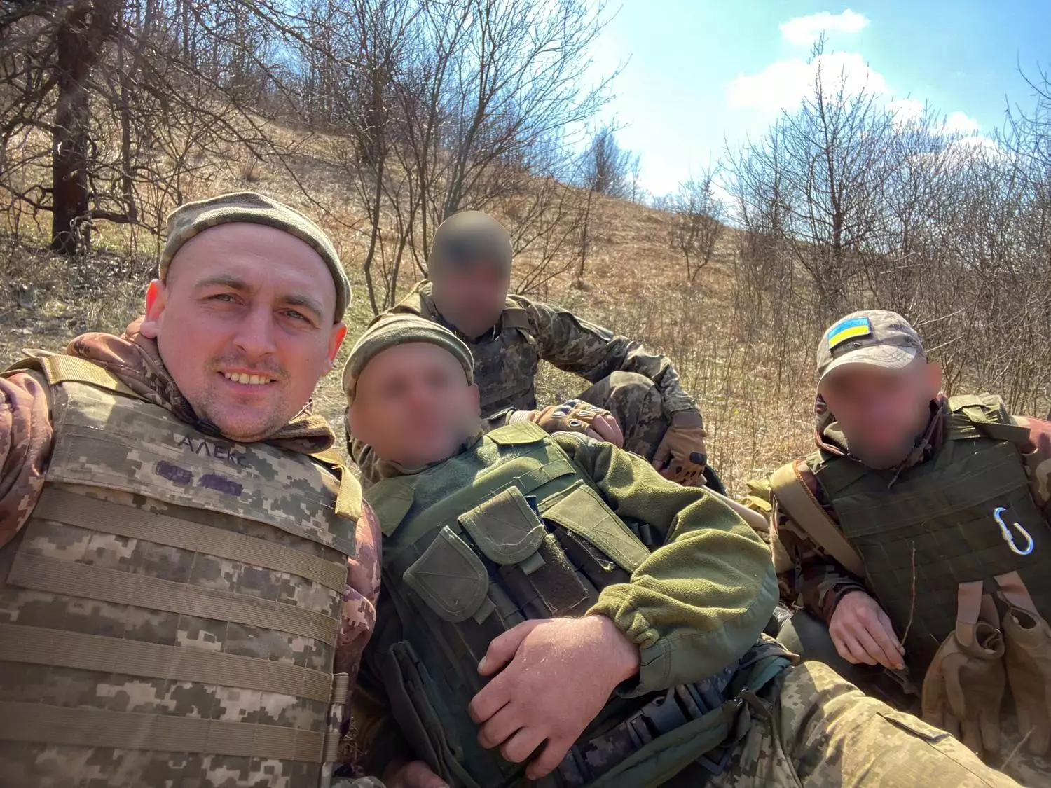 Ветеран у військовій формі з товаришами відпочиває на природі, усміхаючись на камеру