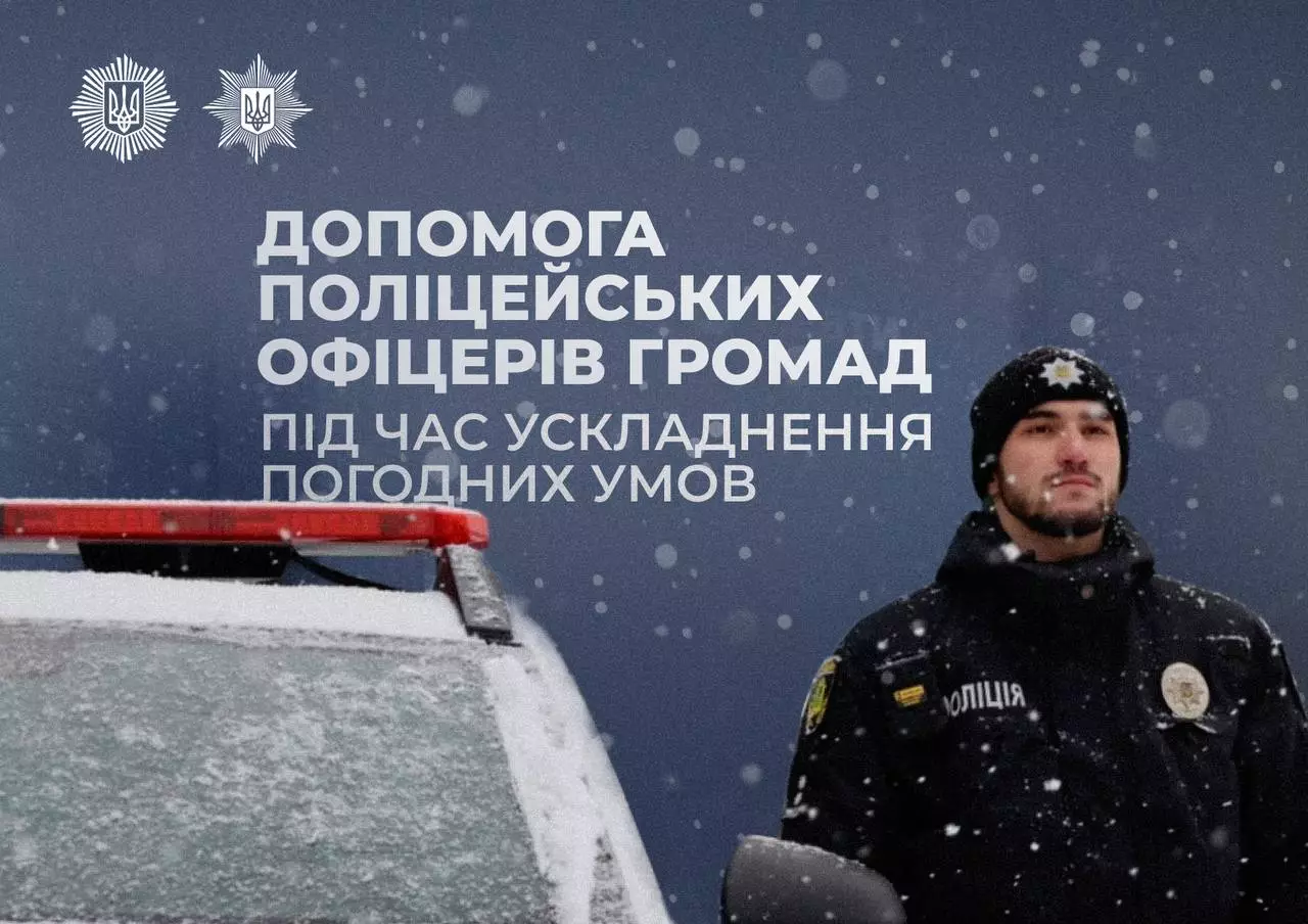 Поліцейський офіцер громади стоїть поруч із патрульним авто під час снігопаду