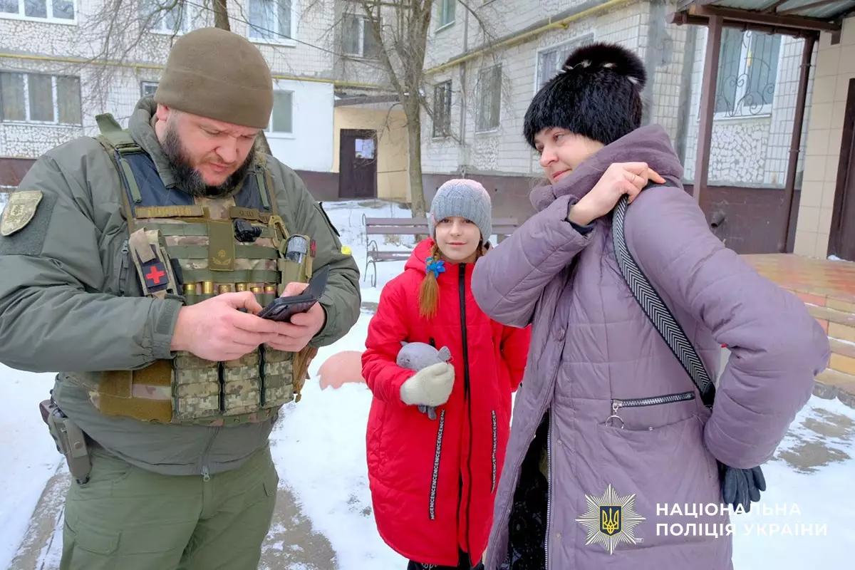 Поліцейський у бронежилеті допомагає жінці та дівчинці під час евакуації з Дружківки