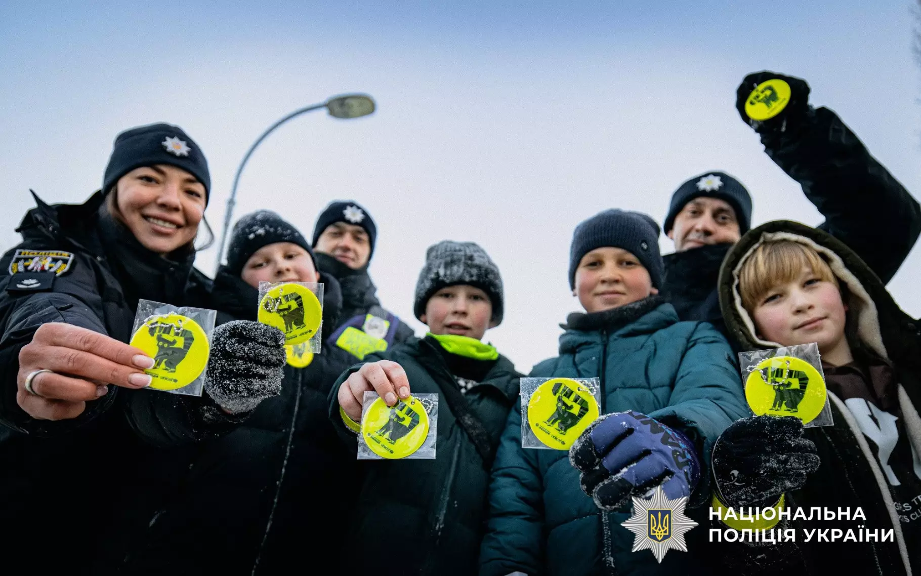 Ювенальні поліцейські роздають дітям світловідбивальні наліпки для безпеки на зимових прогулянках