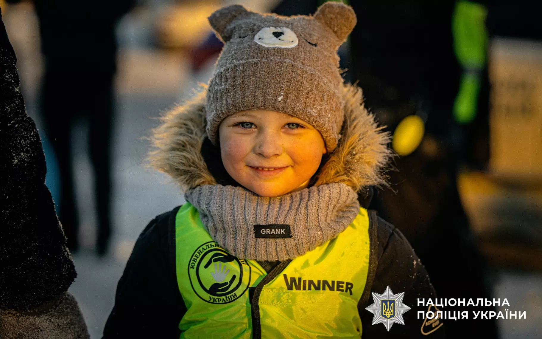 Дитина в шапці ведмедика і світловідбивальному жилеті на профілактичному заході поліції