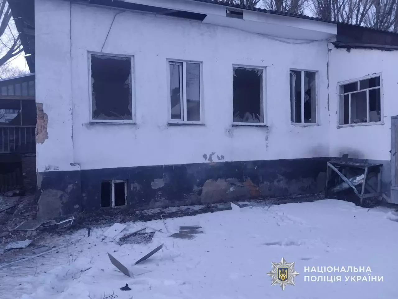 Пошкоджена будівля з вибитими вікнами після обстрілу в Одеській області, сніг на землі