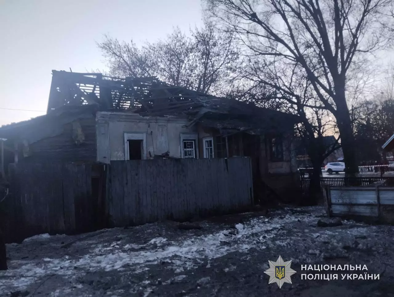 Зруйнований обстрілом будинок на Київщині, пошкоджений дах та стіни, зимовий пейзаж