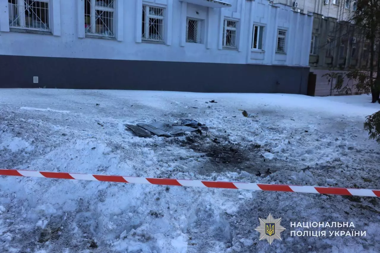 Зруйнована ділянка біля будівлі після обстрілу, обгороджена стрічкою поліції України
