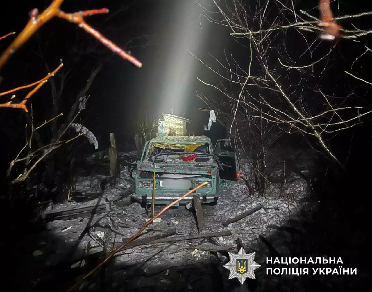 Автомобіль пошкоджений внаслідок обстрілу, навколо уламки, працюють поліцейські України