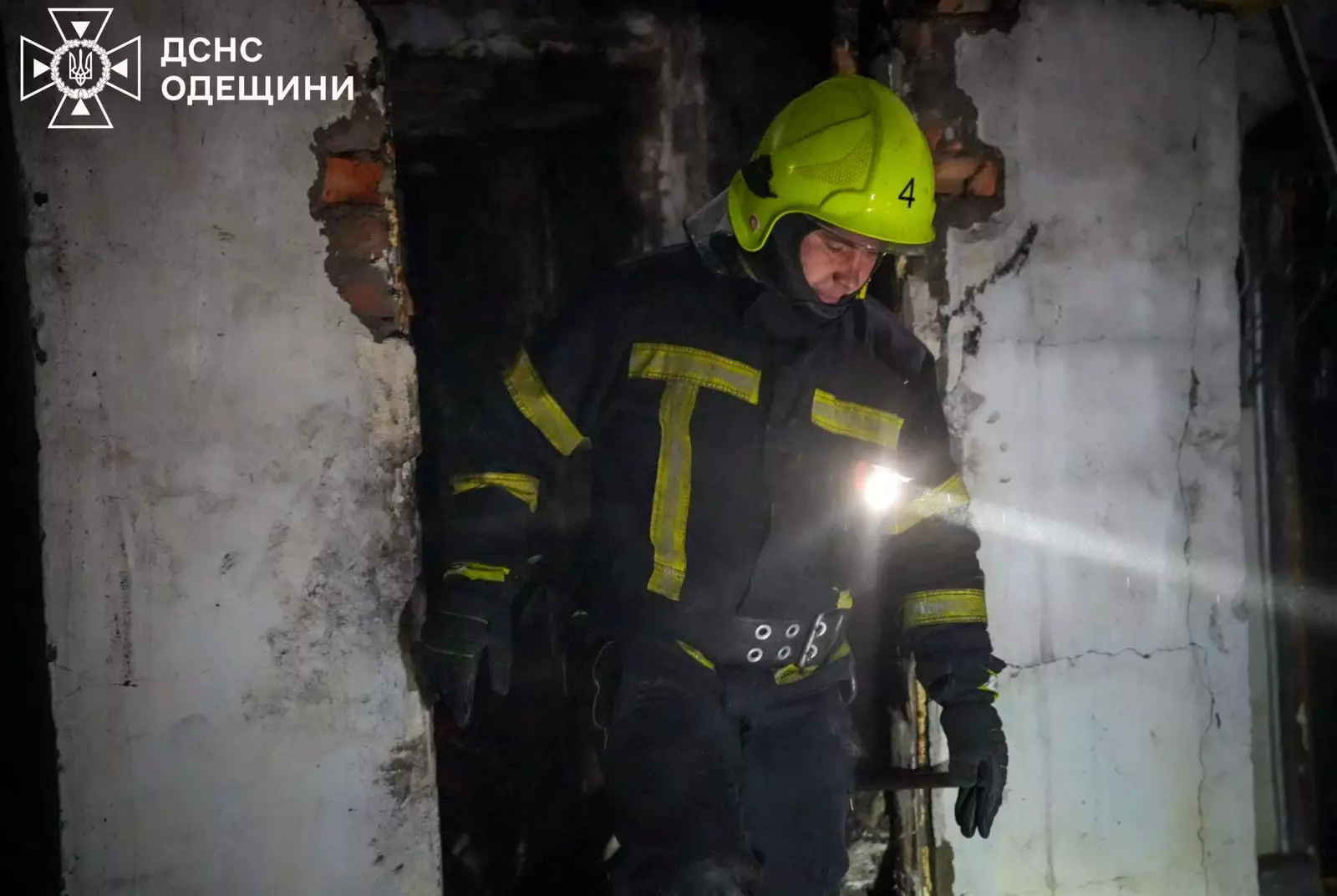 Рятувальник у захисному одязі оглядає пошкоджений будинок після обстрілу на Одещині