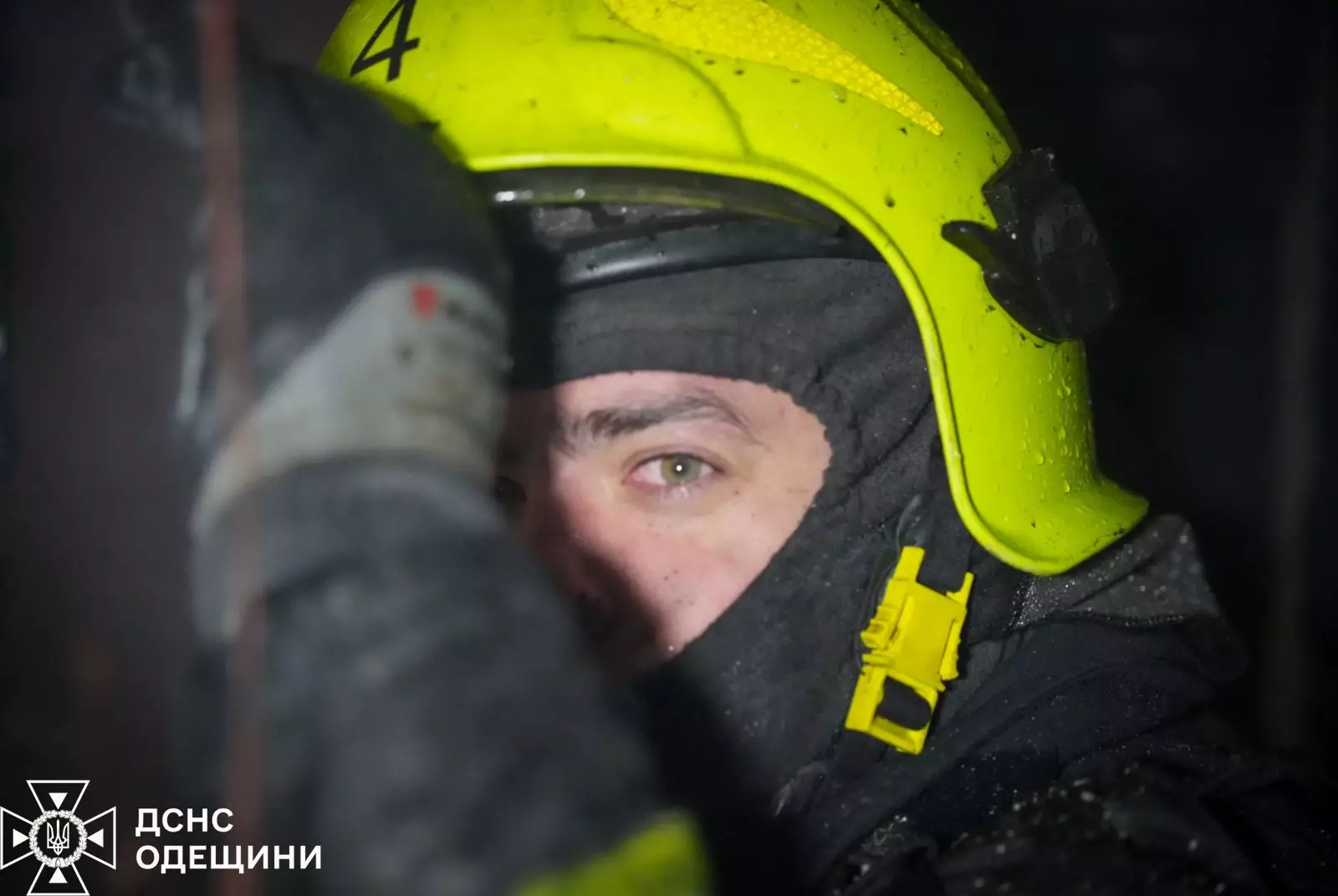 Рятувальник у жовтому шоломі працює на місці обстрілу в Одеській області, фіксуючи наслідки атаки