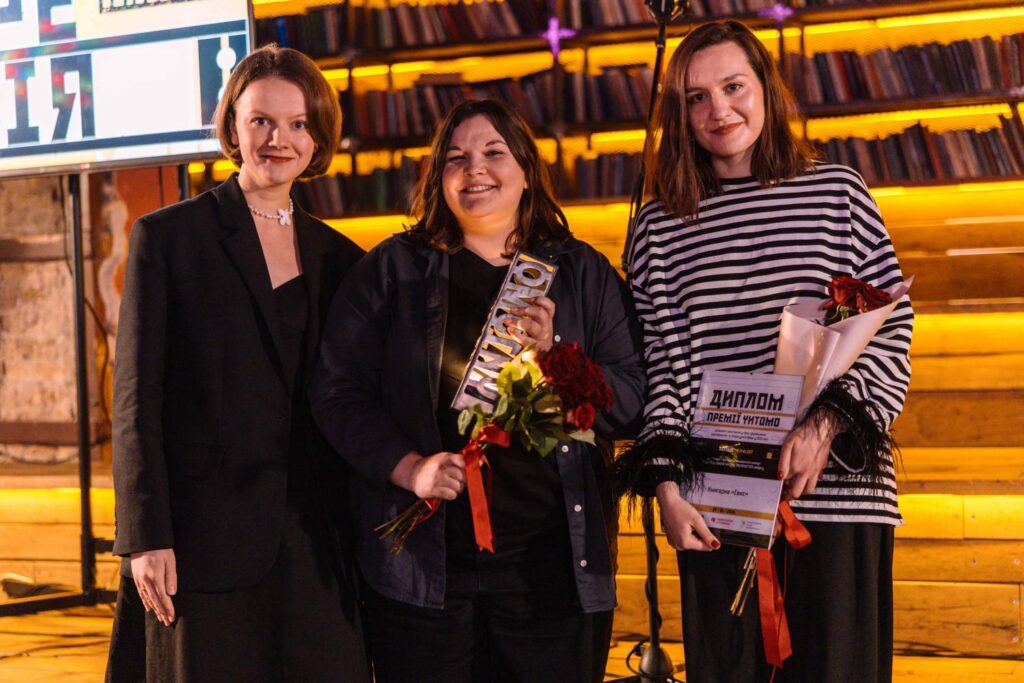 Три жінки з нагородами та квітами на сцені під час церемонії Премії Читомо в Києві