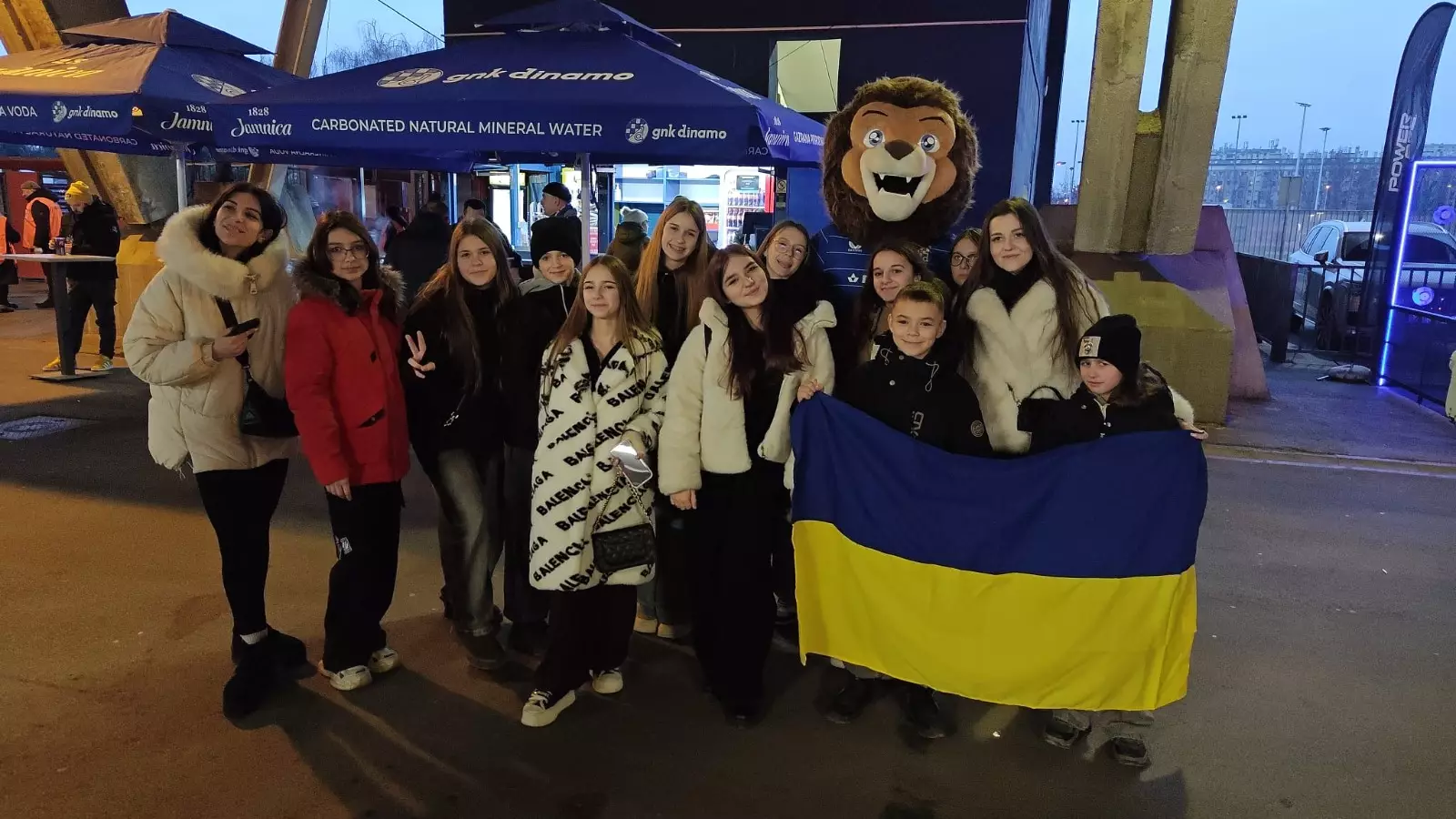 Група дітей з українським прапором на фоні талісмана під час відпочинку в Загребі, Хорватія