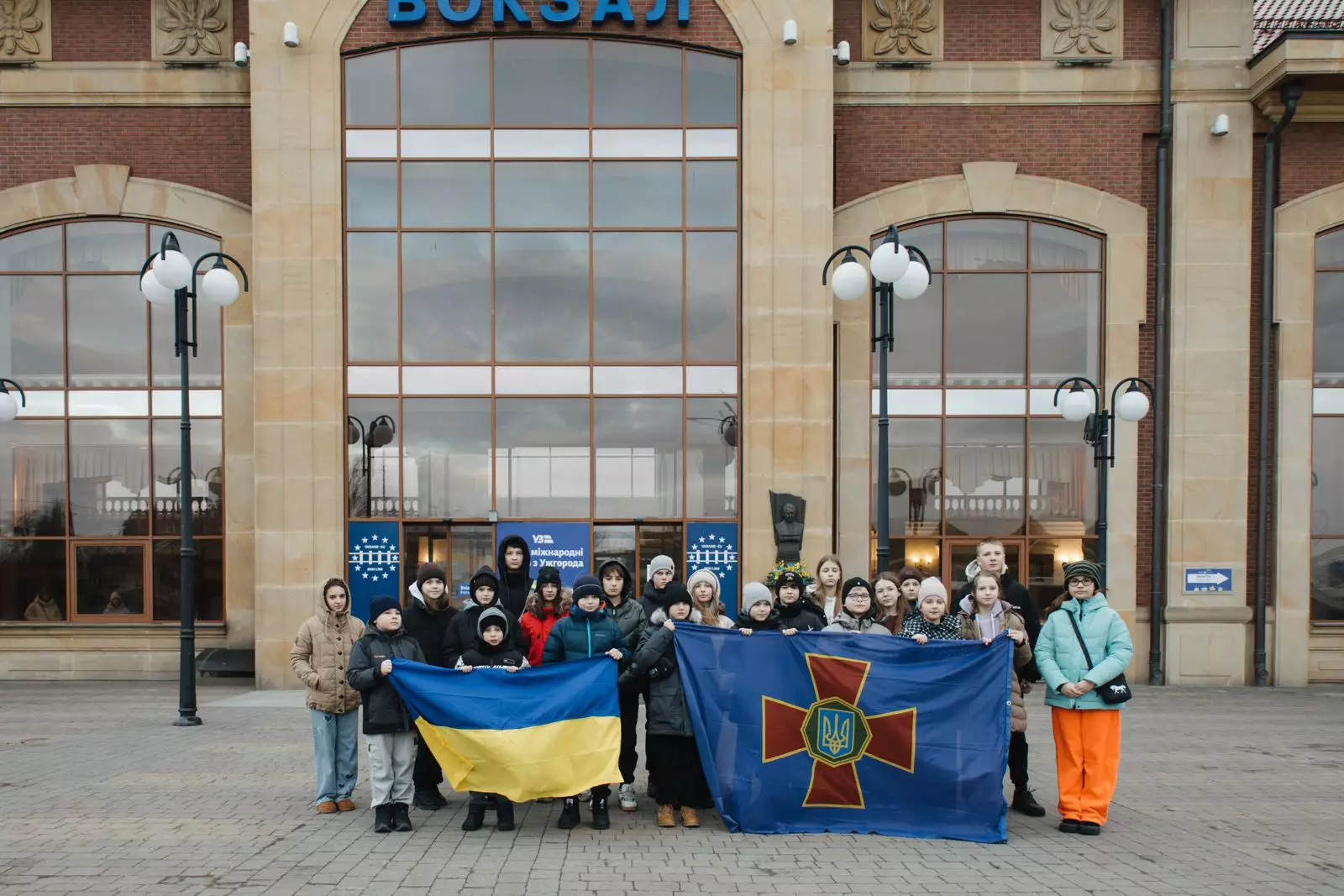 Діти з українськими прапорами перед будівлею в Загребі під час програми «Життя без мін