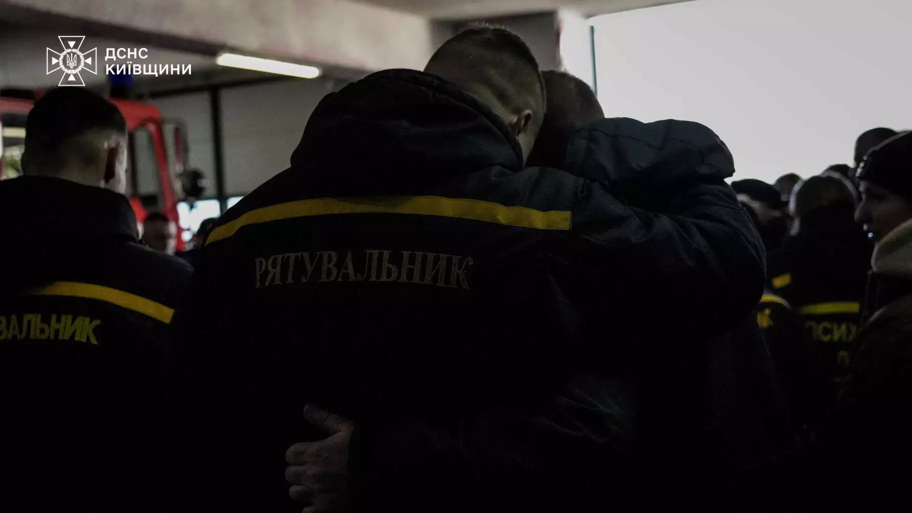 Рятувальники ДСНС обіймаються під час прощання з колегою у пожежній частині на Київщині