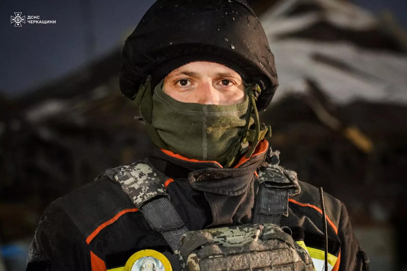 Рятувальник у захисному спорядженні на тлі зруйнованої будівлі після обстрілів у Черкащині