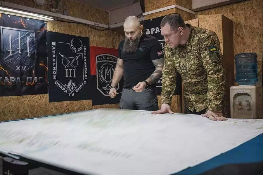 Двоє чоловіків у військовій формі обговорюють карту в штабі з прапорами на стіні