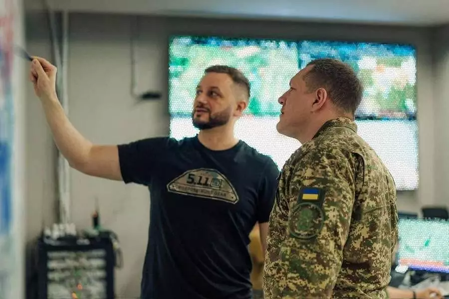 Двоє чоловіків обговорюють стратегію на фоні моніторів у командному центрі Національної гвардії України