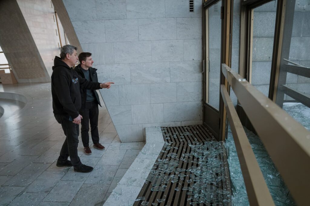 Двоє чоловіків оглядають розбиті вікна в залі слави Національного музею історії України