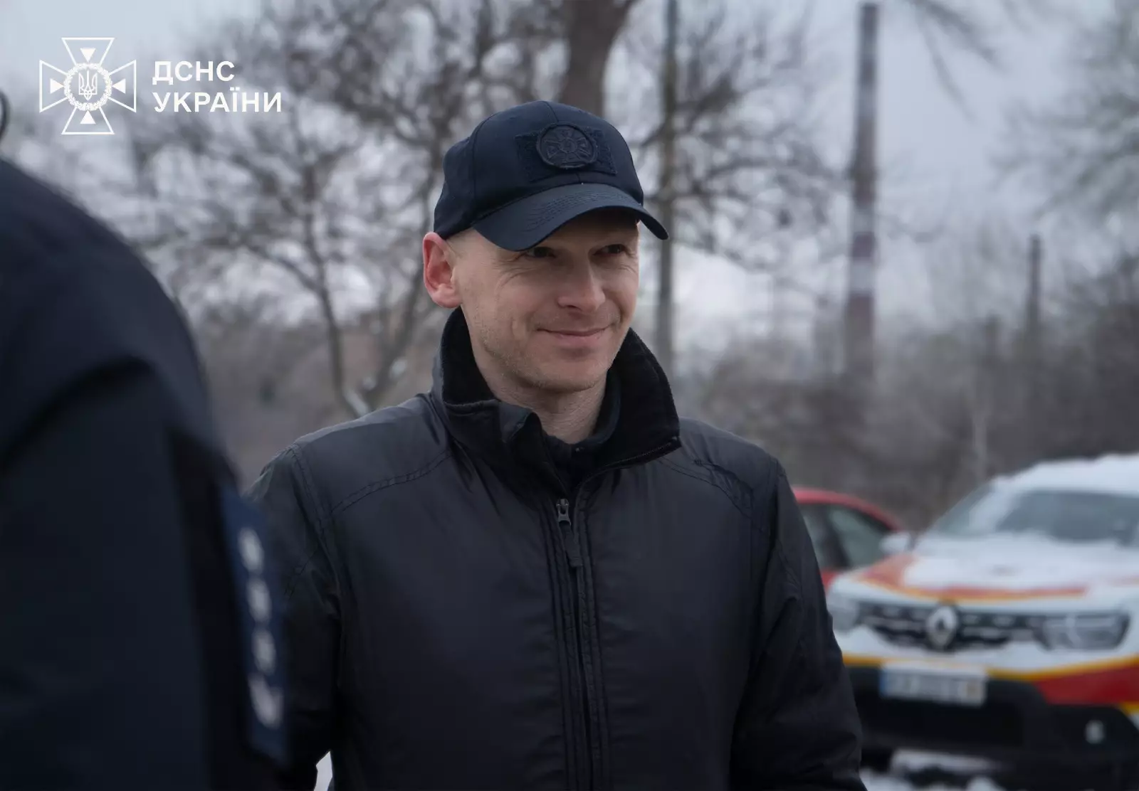 Рятувальник ДСНС України на фоні автомобіля під час церемонії передачі броньованого Volkswagen Transporter