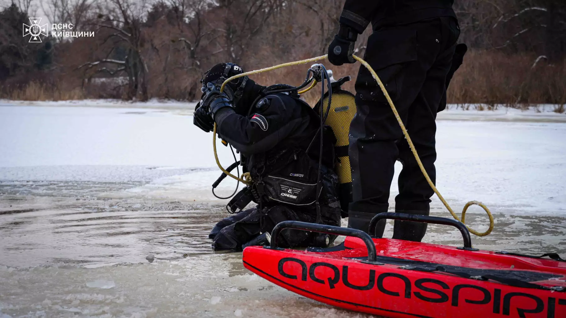 Водолаз у спеціальному спорядженні готується до занурення в крижану воду для пошукових робіт
