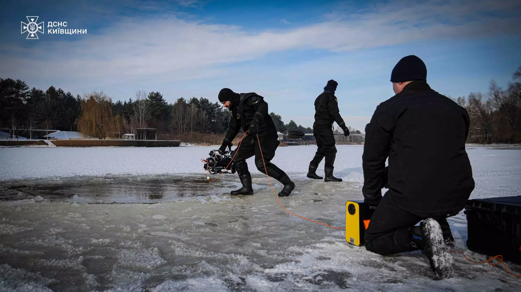 Рятувальники на замерзлій водоймі готуються до підводних пошуків за допомогою спеціального обладнання