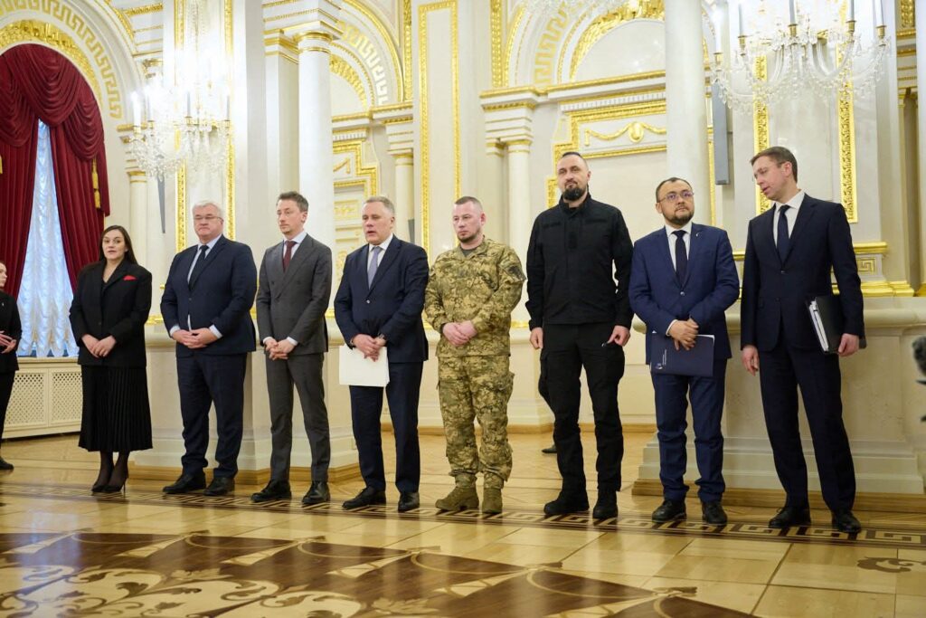 Українська та польська делегації стоять у залі з розкішним інтер'єром під час офіційної зустрічі