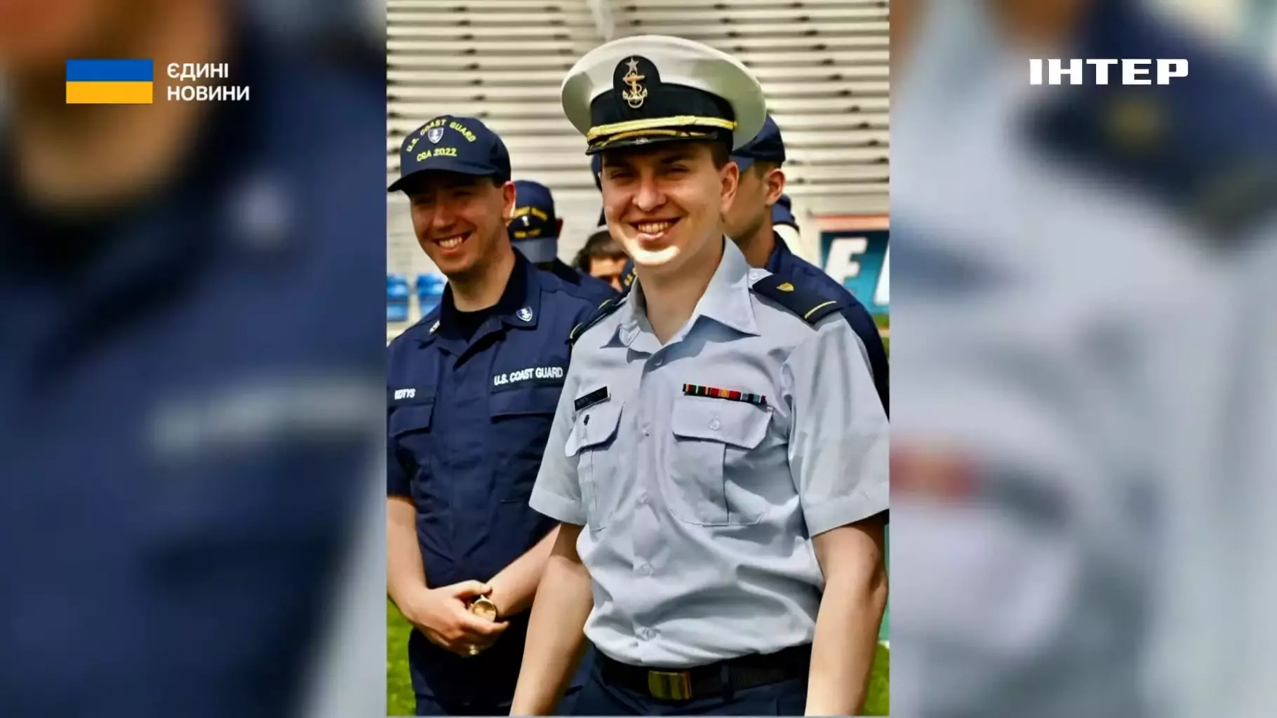 Український офіцер морської охорони в формі усміхається на фоні стадіону під час міжнародного заходу