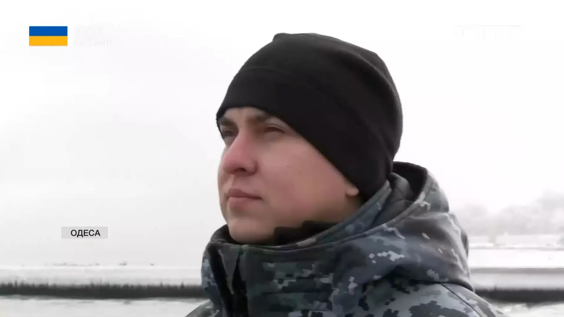 Прикордонник у зимовій формі стоїть на фоні моря в Одесі, символізуючи службу в морській охороні