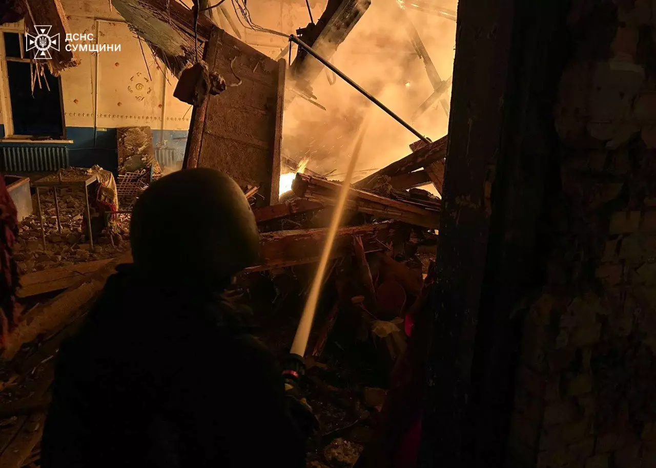 Пожежник гасить полум'я в зруйнованій будівлі після обстрілу, ремонтні роботи тривають