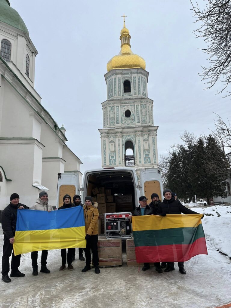 Люди з прапорами України та Литви біля фургона з обладнанням на фоні Софії Київської
