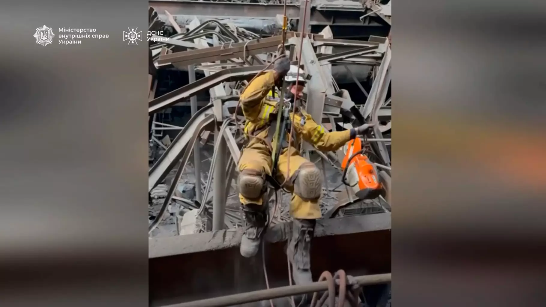 Рятувальник-верхолаз працює серед зруйнованої інфраструктури, використовуючи страхувальне спорядження